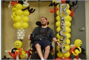 Greg poses by R.I.S.E. Welcome Balloon Arch