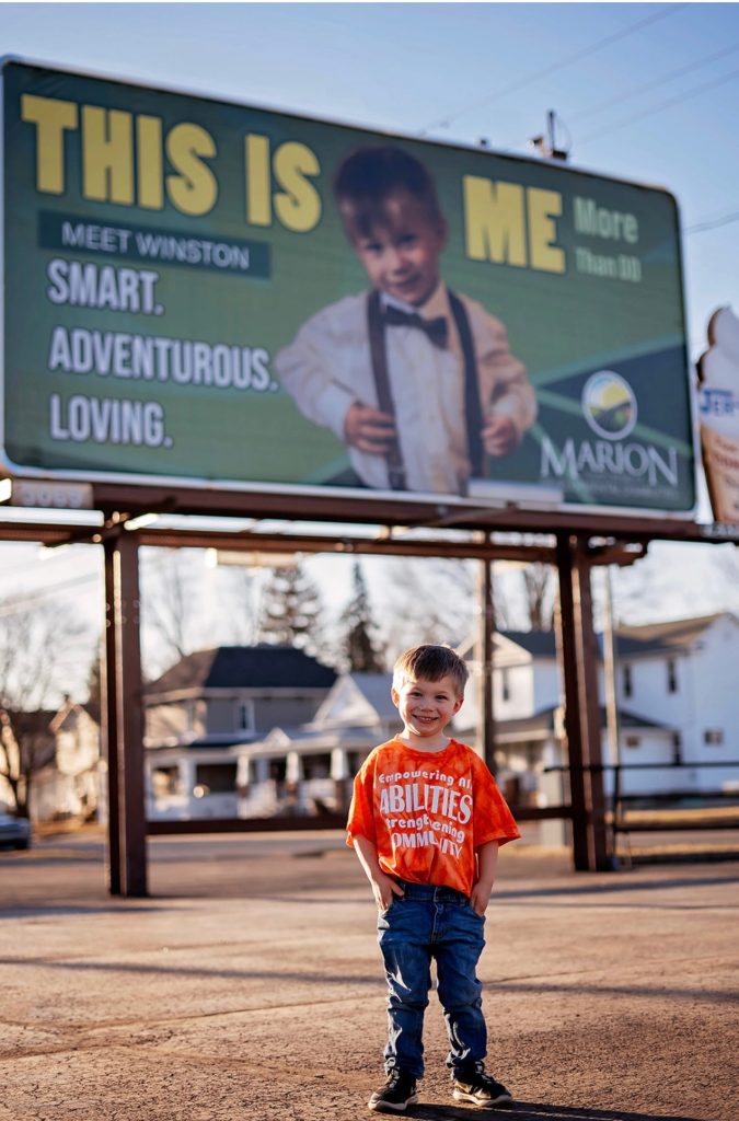 Winston pictured in front of his billboard to help raise awareness for those with developmental disabilities in Marion County.