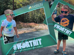 Boys posing in the #WorthIt Frames at the summer bash in 2025
