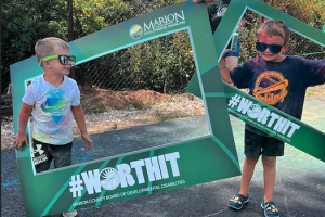 Boys posing in the #WorthIt Frames at the summer bash in 2025